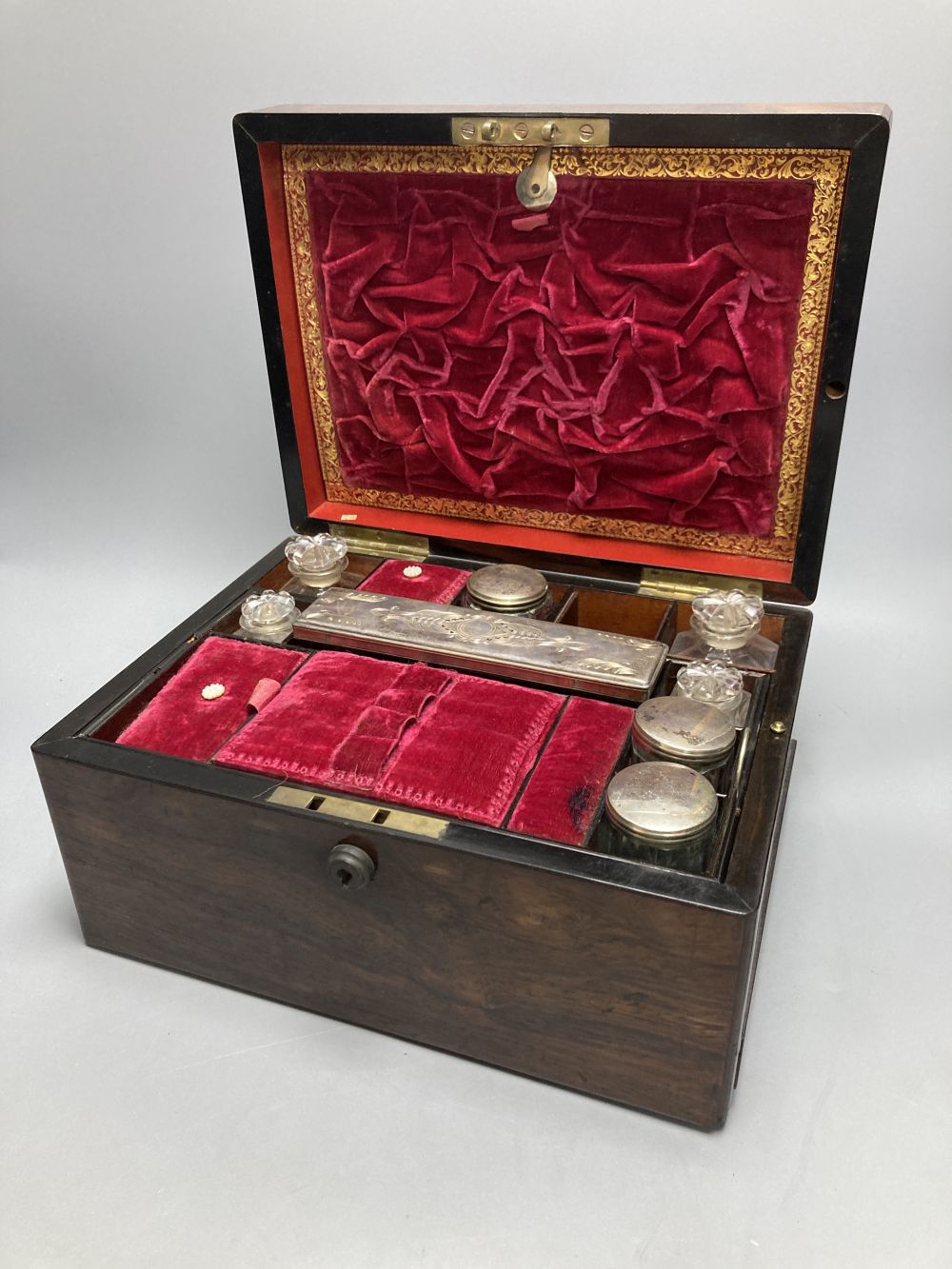 A Victorian rosewood dressing case, with mother of pearl entablature and plate-mounted glass fitments, width 30cm, depth 23cm, height 1